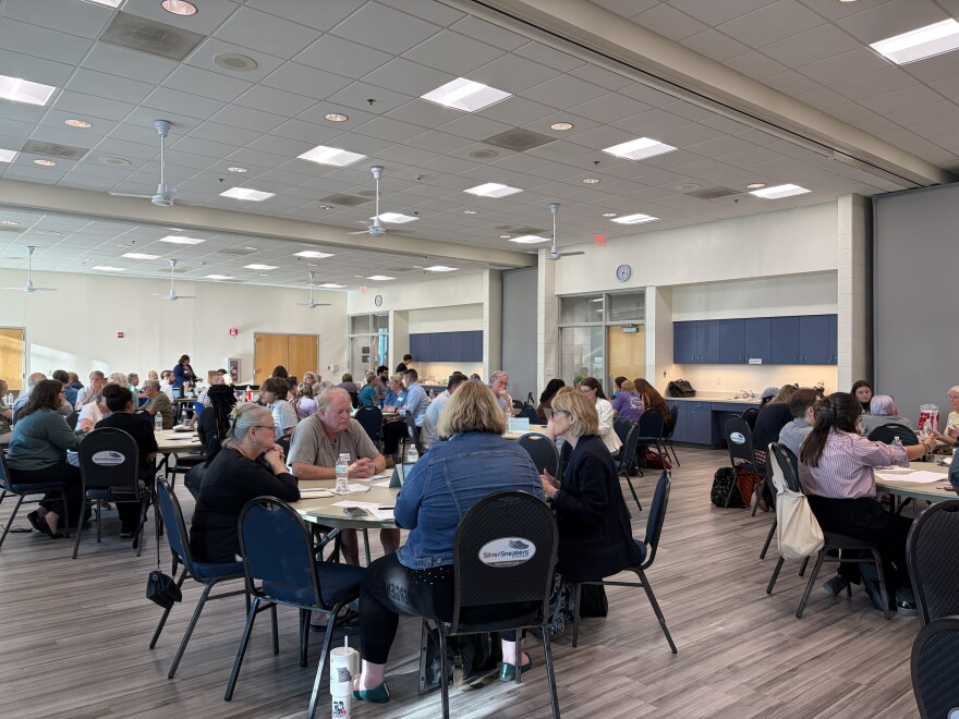 Groups of Columbia residents sit around circular tables at a meeting of the Steering Committee on Homelessness on August 27, 2026.