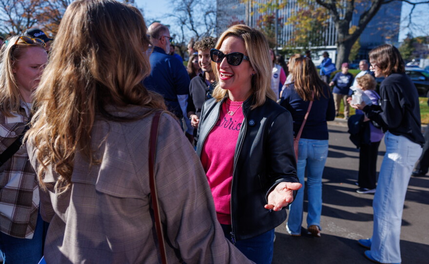 Democratic nominee for governor Jocelyn Benson speaks with a supporter in East Lansing, Mich., during the first stop on her statewide "Driving Down Costs" bus tour on Oct. 22, 2026.