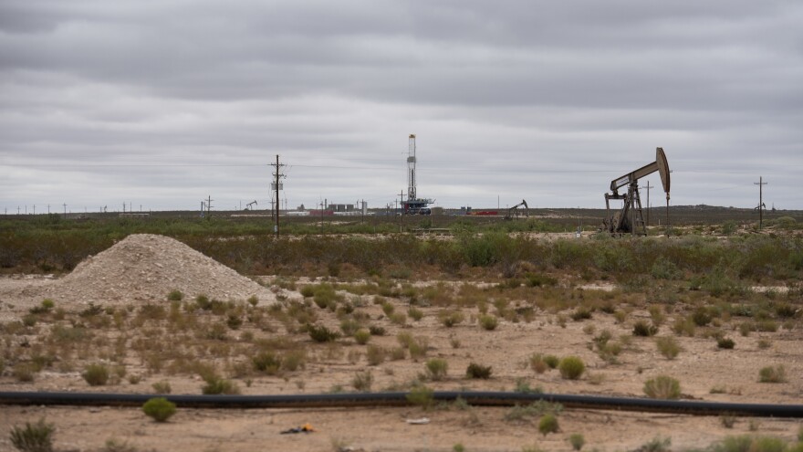 A horizontal drilling rig and a pump jack sit on federal land in Lea County, N.M.