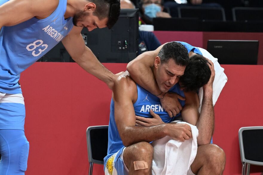 Argentina's Luis Scola, center, is comforted by teammates at the end of the men's quarter-final basketball match between Australia and Argentina on August 3. Scola is retiring from Argentina's national team after the Tokyo Olympics.