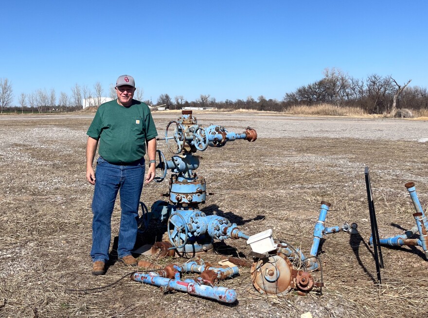 Jeff McCaskill, director of the University of Oklahoma's Tuttle geothermal project, stands next to a retired well the team is converting for geothermal use.