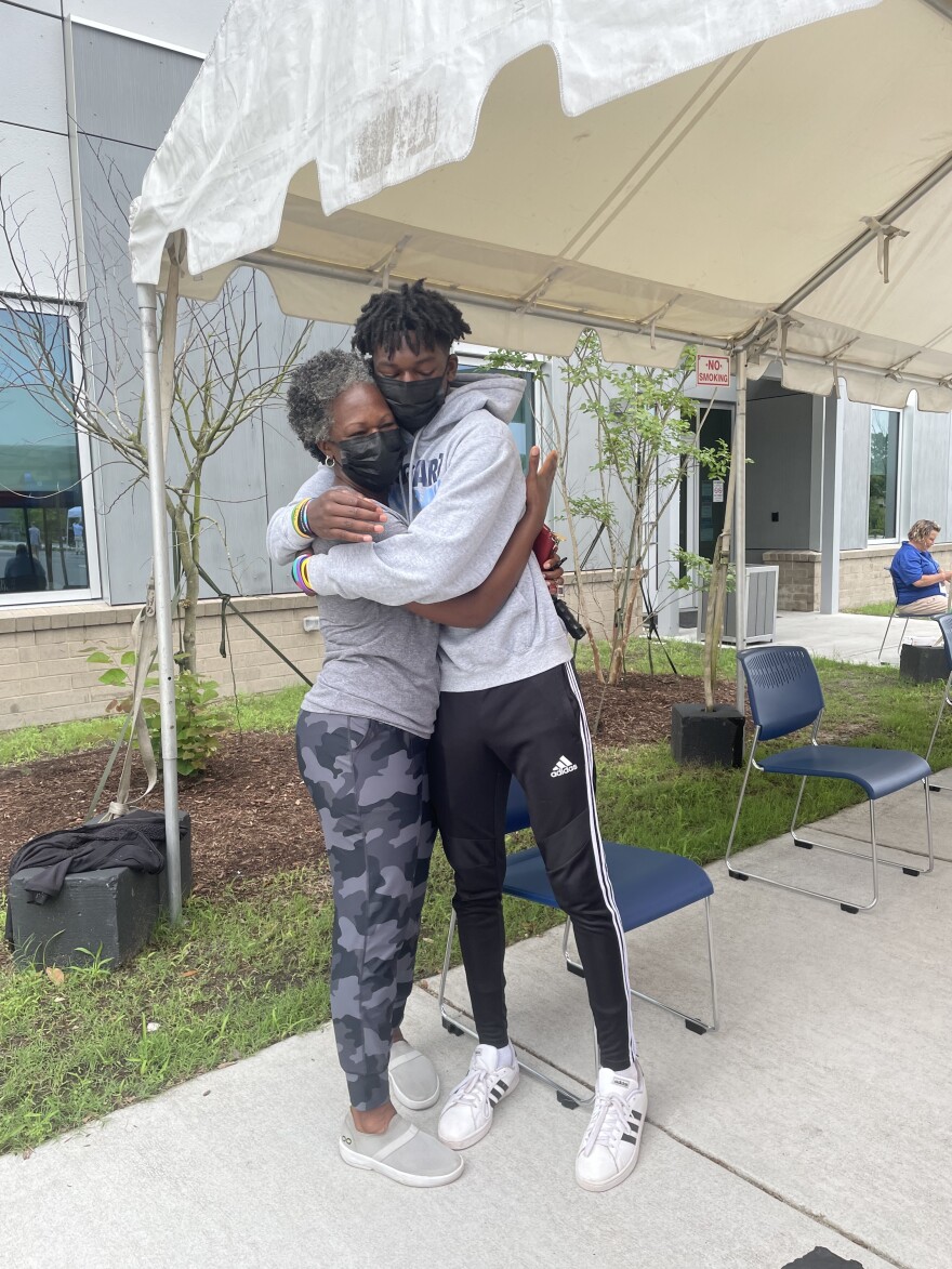 Tanya Armour hugs her 15-year-old son, Elijah, after he got the COVID-19 vaccine.