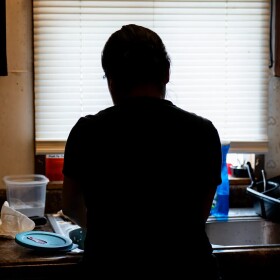 Reyna, who has been cautious of immigration enforcement in the area, washes dishes at her home in February in Baldwin, Wisconsin. After nine years in Wisconsin, Reyna has decided to return to Mexico.