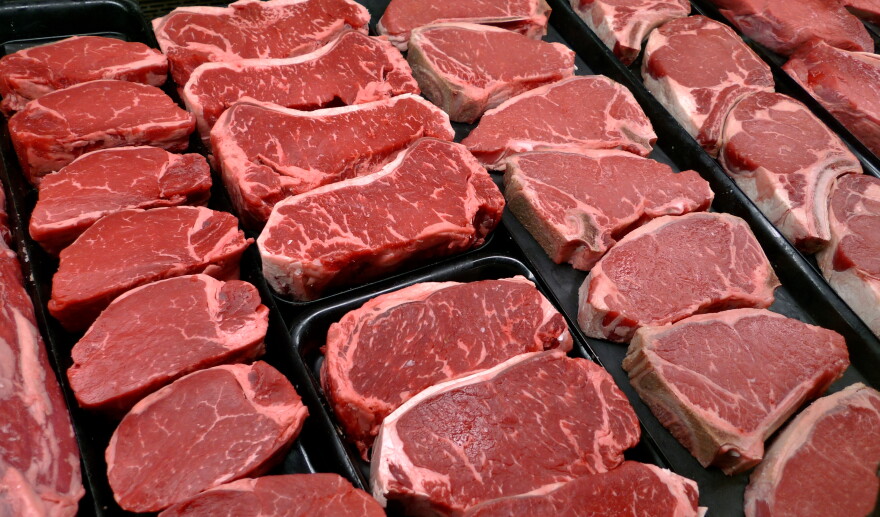 Rows of raw steak in a deli cabinet.