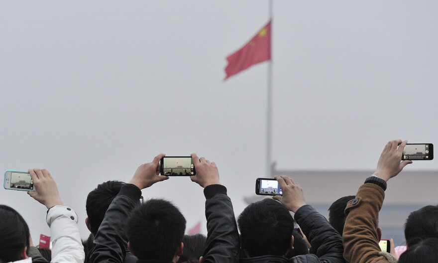 Visitors use their cellphones to record the daily flag-raising ceremony in Tiananmen Square in Beijing on March 3.