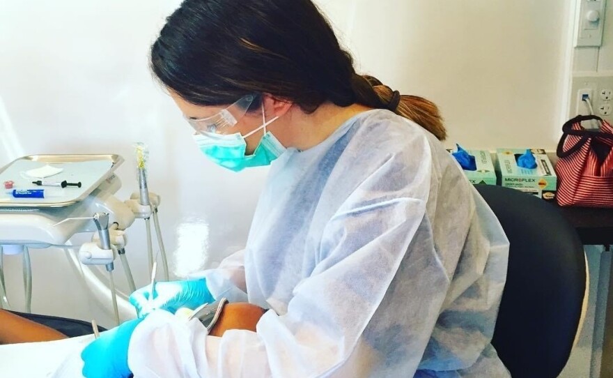 Dental hygienist Alexis Bailey was initially nervous about returning to work but says she quickly grew comfortable with the new protective measures, including a face shield (not shown).