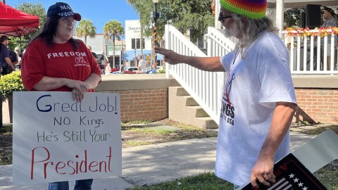 A protester and counterprotester debate. The "No Kings 2.0" rally at the Ocala Historic Downtown Square coincided with a barbecue for supportors of open carry on Saturday, Oct. 18, 2025. (Bailey Diem/WUFT News)