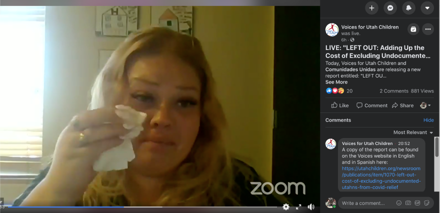 Screengrab of a woman talking on a video call and wiping her eye with a tissue