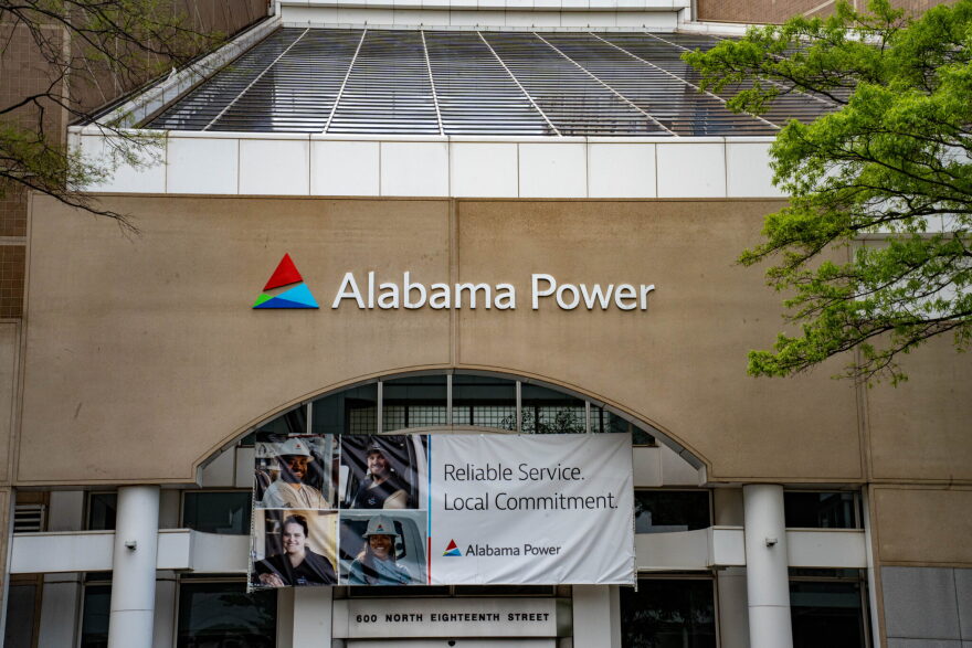 A banner hangs over the entrance to Alabama Power's headquarters. It reads "Reliable Service. Local Commitment."