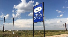 A blue sign in a field says "WCS: Waste Control Specialists" 