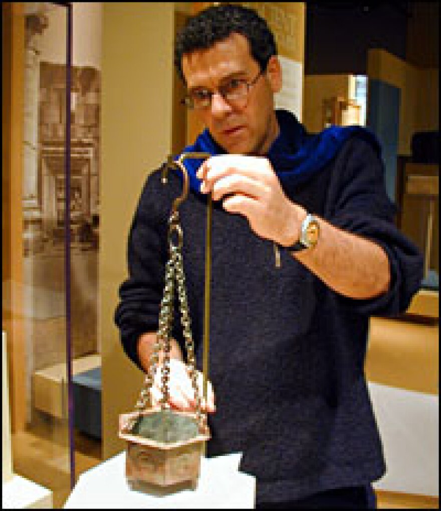 Curator David Mevorah positions an ancient incense container for the Cradle of Christianity exhibit.