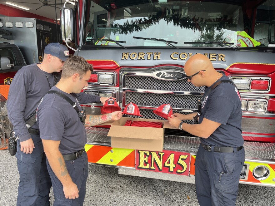 North Collier firefighters check out the plant-based, sustainable helmets they hand out to kids.