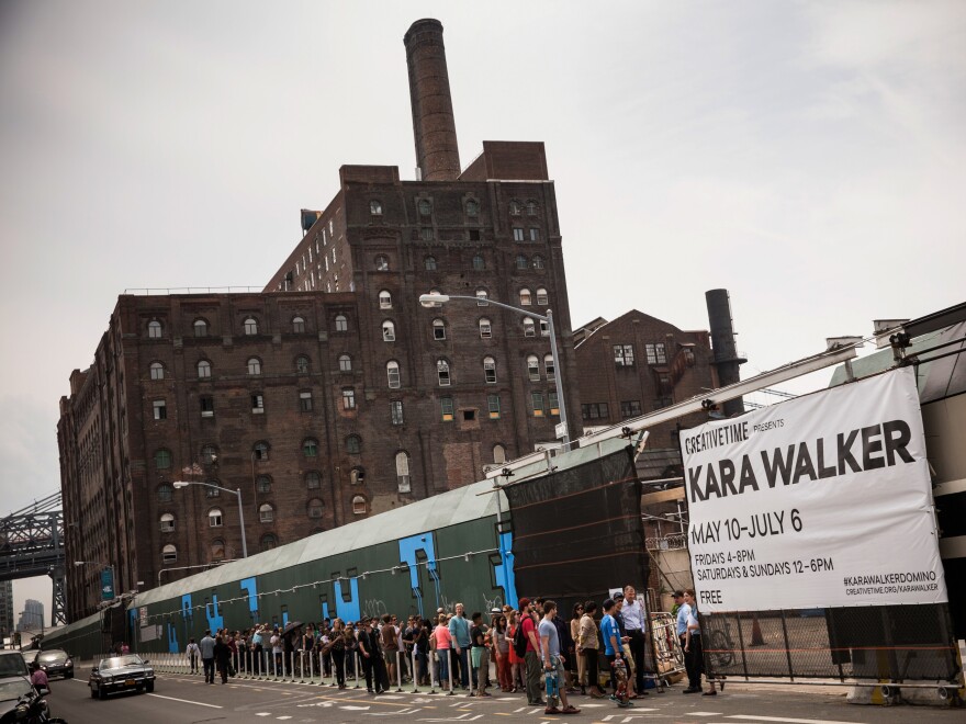 Visitors wait in line for the Kara Walker exhibit on May 10, opening day. The show was housed in a former Domino Sugar refinery. Inside, visitors described the building as "cathedral-like" and "creepy" and said it smelled like a bakery.