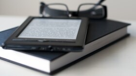 FILE: E-Reader and book with reading glasses.