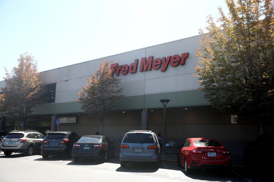 Cars parked in front of a grocery store called Fred Meyer.
