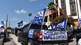 Cars drive through Laredo, Texas, in support of Joe Biden's presidential campaign in October 2020. Several cars tout Biden flags, as well as signs protesting the border wall.