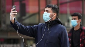 A man takes pictures as he wears a protective face mask at Times Square following the outbreak of COVID-19, in the Manhattan borough of New York City.