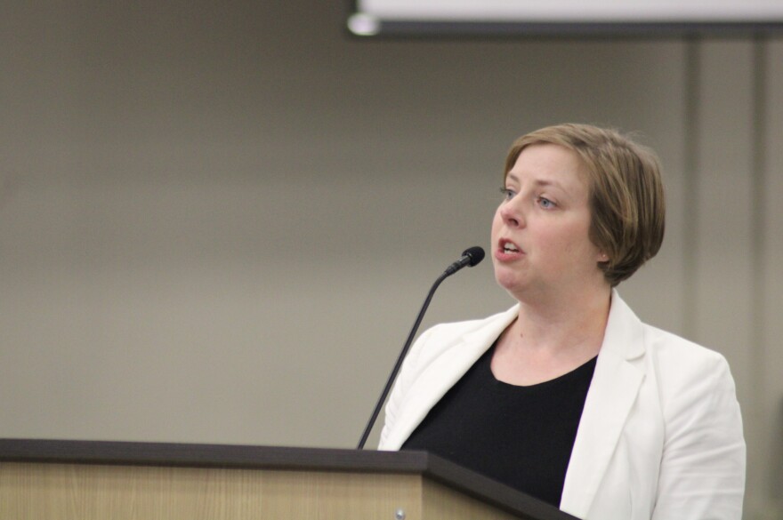 Amy Draut speaks during public forum at the meeting on Monday. She said the school closures will harm students and families in surrounding neighborhoods.