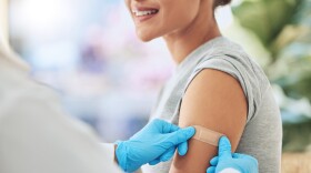 Band aid, vaccine or injection for covid and global virus in security, safety or wellness insurance. Doctor hands, medical employee or healthcare worker with plaster for happy or smile hospital woman.