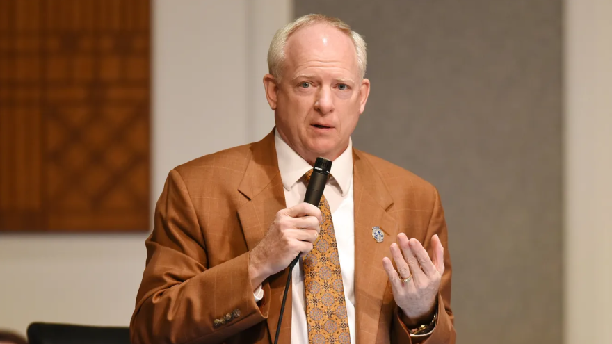 Bowman speaking at microphone at City Hall