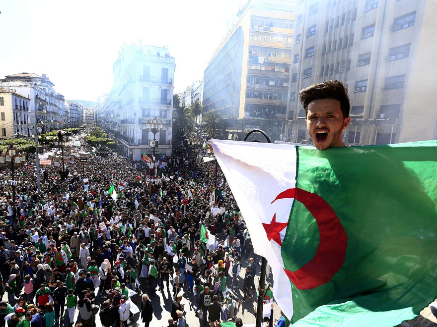 Algerian shouts as he holds the national flag during a protest in Algiers, Algeria, on Friday.