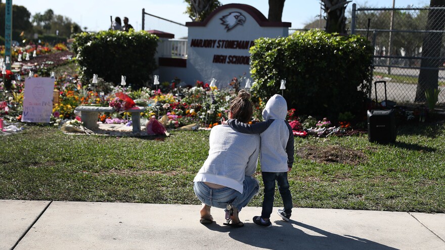 A memorial is seen outside Marjory Stoneman Douglas High School in Parkland, Fla., in honor of those killed during a 2018 mass shooting. Families of more than a dozen victims have reached a legal settlement with the Justice Department.