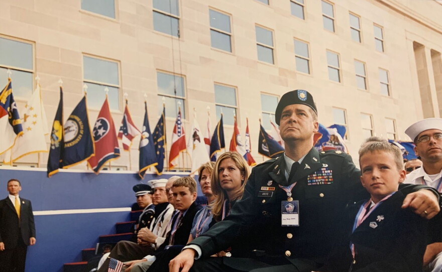 A group of military members and their families are sitting while attending a ceremony.