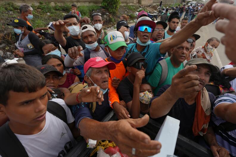 People reach out to receive supplies from volunteers, days after an earthquake struck La Guaira, Venezuela, Tuesday, June 30, 2026.