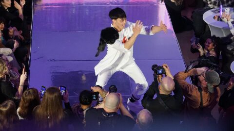 Martin Paul, a University of Alaska Fairbanks student from Kalskag and Kipnuk, makes traditional dance moves on the catwalk at the seventh annual Far North Fashion Show, held on April 15. 2026, at the Anchorage Museum. Paul’s outfit incorportes the red handprint that symbolizes missing and murdered Indigenous people. The fashion show is a highlight of the annual Arctic Encounter Summit.