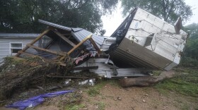 A mobile home and a truck trailer sit near a creek Sunday after they were washed away by flood waters the day before in McEwen, Tenn. Heavy rains caused flooding in middle Tennessee and have resulted in multiple deaths as homes and rural roads were washed away.