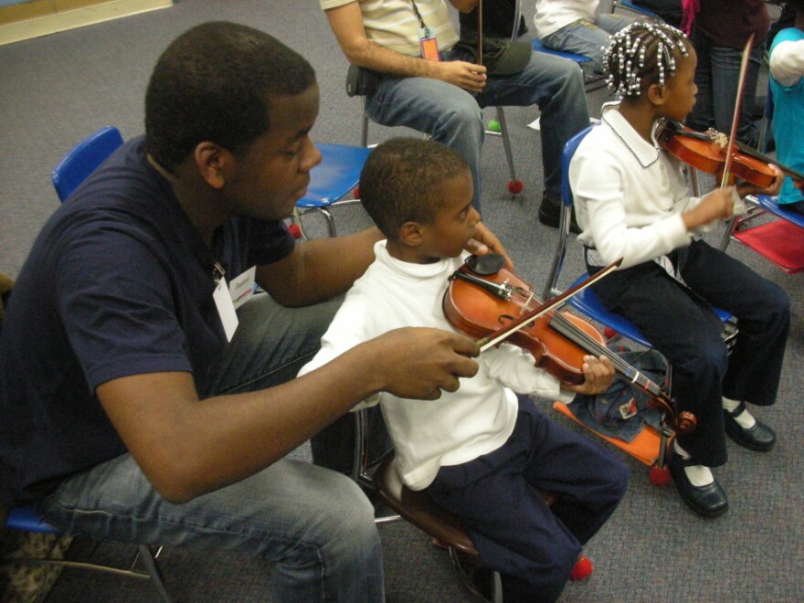 Stanford Thompson, another Abreu Fellow alum, adjusts a student's bowing in a <em>nucleo</em> in Philadelphia.