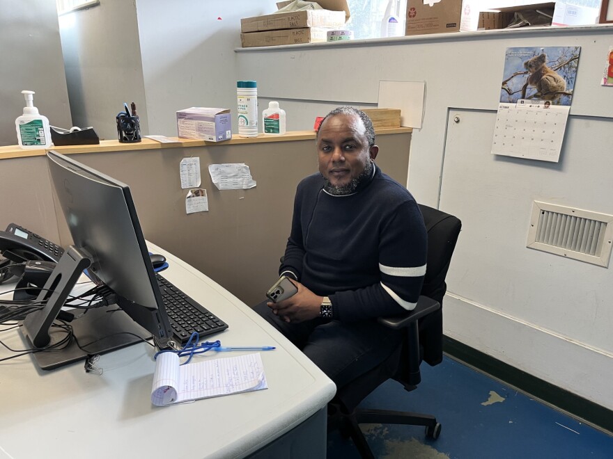 A photo of a man at a desk, looking into the camera. 