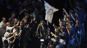 Tom Cruise rides a motorbike during the 2024 Summer Olympics closing ceremony at the Stade de France, Sunday, Aug. 11, 2024, in Saint-Denis, France. (AP Photo/Dita Alangkara)