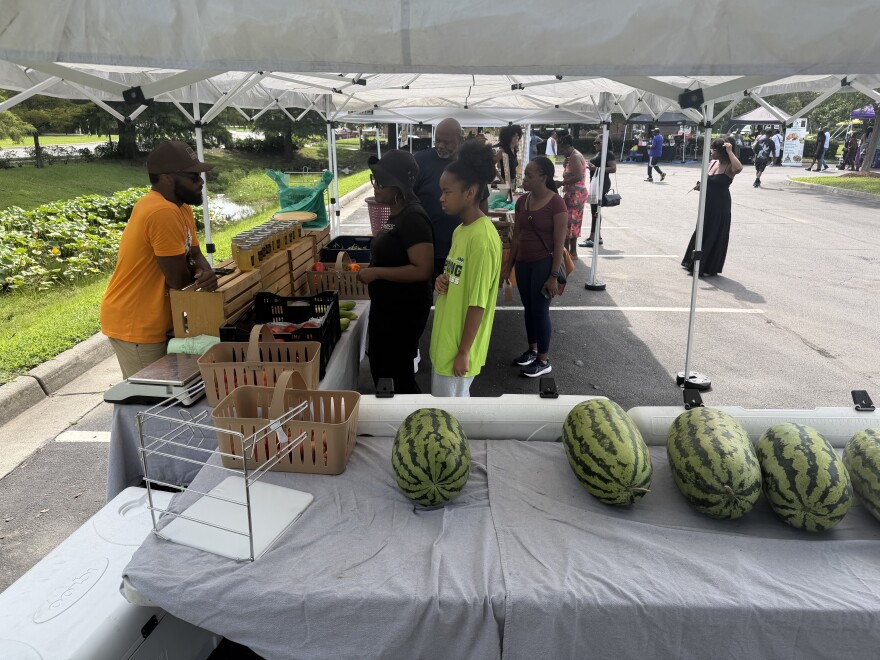 Thelonious Cook chats with customers at his produce stand outside E. Palmer Supermarket during the Mid-Atlantic Black Farmers Market in Berkley. The market runs on the first and third Saturday of each month through November.