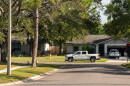 View of houses with a truck on the side of the road and a car in the driveway