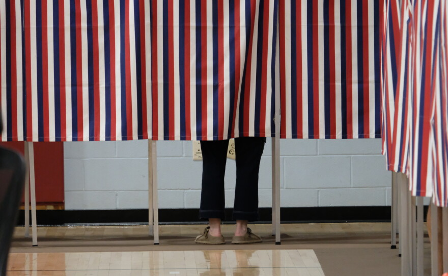 A voter filling out their ballot behind the patriotic curtain at Rye Elementary School on Sept. 8, 2026.