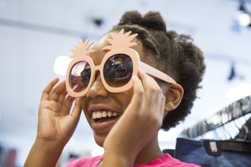 Karisma Clark tries on sunglasses while her mom Ayeisha Owens and sister Kaiden Clark shop for some last minute back-to-school clothes on Saturday, August 18, 2018.