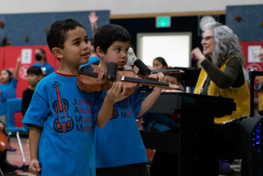 indergartners at Sítʼ Eetí Shaanáx̱ Glacier Valley Elementary School play paper violins as part of a Lingít language immersion and music program on Dec. 9, 2022. (Photo by Andrés Javier Camacho/KTOO)