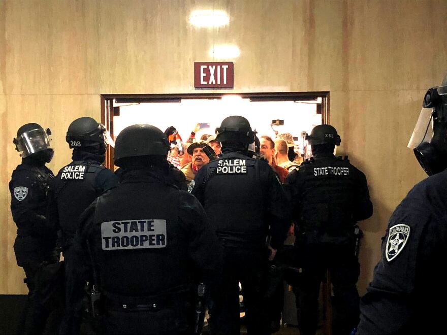 Police block an entryway to the Oregon Capitol as far-right protesters attempt to gain access on Dec. 21, 2020.