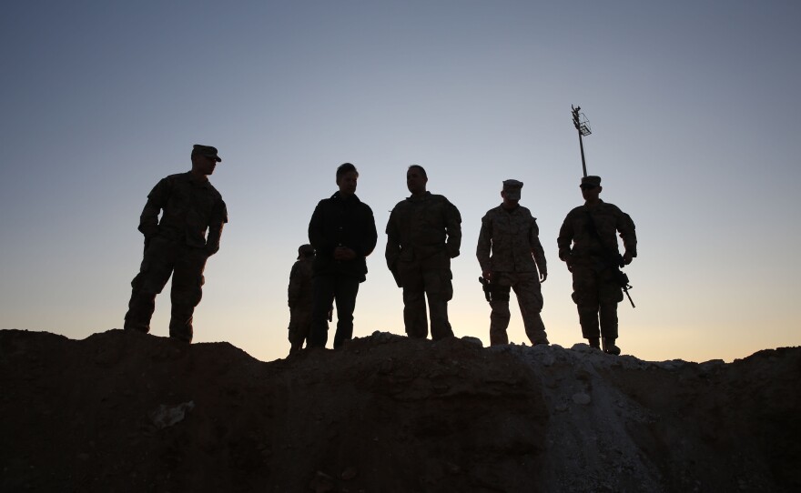 U.S. service members stand at Ain al-Assad base at dusk on Monday.
