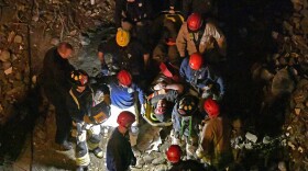 Members of the Louisville Metro Fire Department carry an injured worker to safety after being trapped under rubble at construction site in Louisville, Ky., Thursday, Nov. 14, 2024.