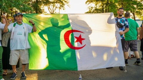 Algeria fans hold up the country's flag at the Cortège Parade at the DoubleTree Inn in Lawrence, Kansas.