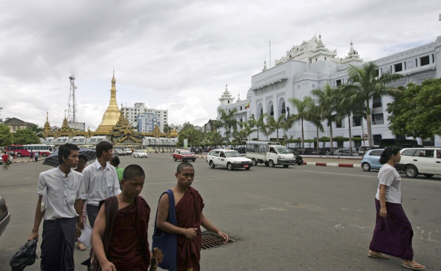 Buddhist monks and others walk across a road in downtown Yangon, Myanmar, on May 13.