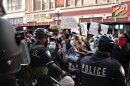 Police officers in riot gear face protestors in downtown San Antonio on Saturday May 30, 2020.