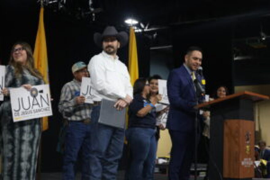 Juan de Jesus Sanchez III, left in cowboy hat, listens to U.S. Rep. Gabe Vasquez (D.N.M.) introduce him to Democratic party delegates at the party’s pre-primary convention March 7, 2026 in Mescalero.