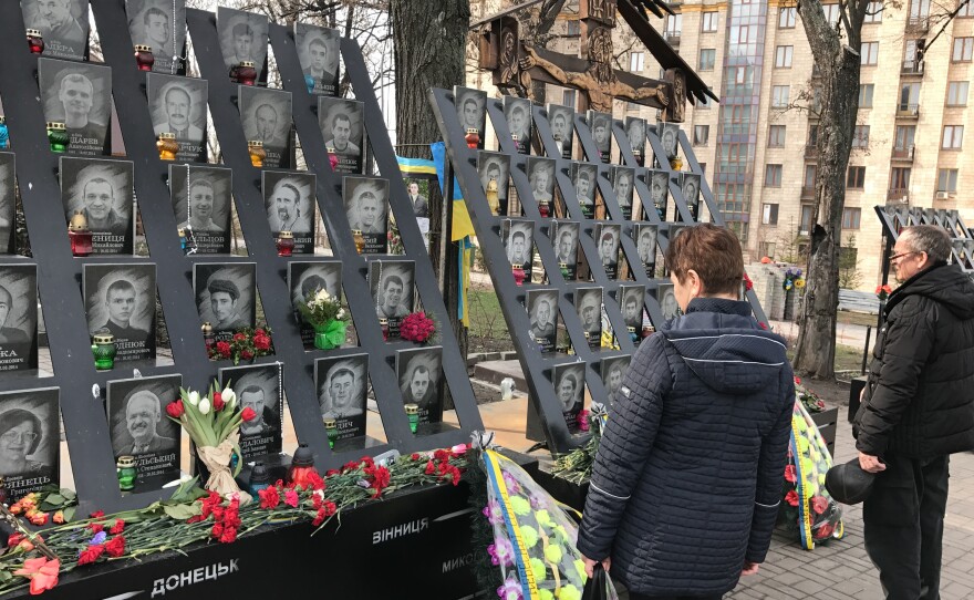 Passersby pay tribute to activists who were killed during 2014 anti-government protests near the Maidan, Kiev's main square.