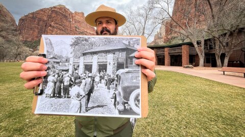 Park education supervisor Jorge Hernandez holds a historic photo of the Zion Lodge in front of the hotel’s modern entrance, Feb. 11, 2026.