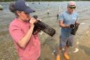WHOI Research Associate Andria Salas and Senior Scientist Aran Mooney inspect underwater recording devices called SoundTraps after retrieving them from Tisbury Great Pond on Martha’s Vineyard. July 15, 2026 (Barbara Moran/WBUR)