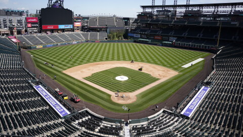 Crew members toil on Coors Field before a baseball game as the Colorado Rockies host the Arizona Diamondbacks, Sunday, May 23, 2021, in Denver.