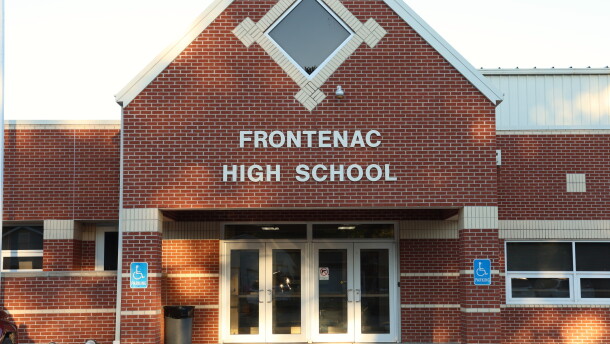 A picture of Frontenac High School. It's a red brick building, and the picture shows the front entrance with "Frontenac High School" about the doors.